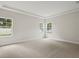 This bedroom with neutral carpet features lots of natural light from the large windows at 4523 Foley Grove Dr, Valrico, FL 33596