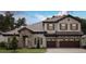 Charming two-story home with stone accents, a tile roof, a three-car garage, and manicured landscaping at 4523 Foley Grove Dr, Valrico, FL 33596