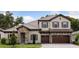 Charming two-story home with stone accents, a tile roof, a three-car garage, and manicured landscaping at 4523 Foley Grove Dr, Valrico, FL 33596
