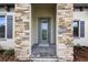 Elegant front door with stone surround and patterned glass, complemented by manicured landscaping at 4523 Foley Grove Dr, Valrico, FL 33596