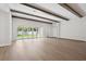 Spacious living room featuring wood floors, beamed ceilings, and large sliding glass doors to the backyard at 4523 Foley Grove Dr, Valrico, FL 33596
