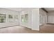 Living room with three large windows, hardwood floors, and an open doorway to an adjacent room at 4523 Foley Grove Dr, Valrico, FL 33596