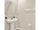Powder room with a pedestal sink, round mirror, and neutral wall color at 5067 Sable Chime Dr, Wimauma, FL 33598