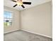 This bedroom features carpeted floors, a ceiling fan, and a window at 5067 Sable Chime Dr, Wimauma, FL 33598