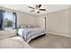 Carpeted bedroom featuring a ceiling fan, neutral walls, and a window with blue curtains at 5067 Sable Chime Dr, Wimauma, FL 33598