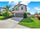 Charming two-story home featuring a two-car garage, landscaped yard, and fenced area at 5067 Sable Chime Dr, Wimauma, FL 33598