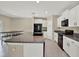 Modern kitchen with white cabinets, granite countertops, black appliances, and breakfast bar at 5067 Sable Chime Dr, Wimauma, FL 33598