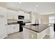 Modern kitchen featuring granite countertops, white cabinets, and black appliances at 5067 Sable Chime Dr, Wimauma, FL 33598
