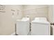 Laundry room with white washer and dryer and laundry-themed wall art at 5067 Sable Chime Dr, Wimauma, FL 33598