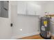 Basement area featuring updated water heater, modern overhead storage cabinets, and wood-look flooring at 526 62Nd Ne Ave, St Petersburg, FL 33702