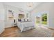 Bedroom features modern lighting, white walls, wood-look flooring, and sliding glass doors that leads to yard at 526 62Nd Ne Ave, St Petersburg, FL 33702