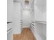 Walk-in closet features custom white shelving, drawers, and modern lighting for storage and organization at 526 62Nd Ne Ave, St Petersburg, FL 33702