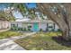 Inviting single-story home with a turquoise door, enhanced by a lush, green lawn at 526 62Nd Ne Ave, St Petersburg, FL 33702