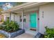 Close-up of a charming turquoise front door with a welcoming 'welcome' mat at 526 62Nd Ne Ave, St Petersburg, FL 33702