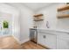 Bright kitchen featuring a farmhouse sink, open shelving, and stainless steel dishwasher at 526 62Nd Ne Ave, St Petersburg, FL 33702