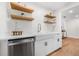 Charming kitchen features a farmhouse sink, open shelving, stainless steel appliances, and light wood flooring at 526 62Nd Ne Ave, St Petersburg, FL 33702