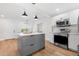 Updated kitchen showcasing an island with storage, stainless steel appliances, and light wood floors at 526 62Nd Ne Ave, St Petersburg, FL 33702