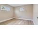 Bedroom featuring light wood flooring, neutral walls and two bright windows at 5470 Bayshore Dr, Seminole, FL 33772