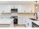 Bright kitchen featuring stainless steel appliances, white cabinets, and quartz countertops at 5470 Bayshore Dr, Seminole, FL 33772