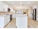 Modern kitchen with white cabinets, stainless steel appliances, and a center island overlooking the living area at 5470 Bayshore Dr, Seminole, FL 33772