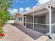 View of a home's screened in lanai with brick pavers extending to the main structure at 5470 Bayshore Dr, Seminole, FL 33772