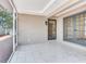 Covered patio with white tile flooring and access to the yard at 5470 Bayshore Dr, Seminole, FL 33772