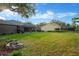 Expansive backyard featuring a screened pool, lush lawn, and inviting fire pit area for outdoor relaxation at 5825 Terncrest Dr, Lithia, FL 33547