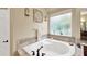 Bathroom featuring a white corner tub with tile surround, window, and vanity at 5825 Terncrest Dr, Lithia, FL 33547