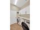 Functional laundry room with modern washer and dryer, ample cabinet space, and stylish tile flooring at 5825 Terncrest Dr, Lithia, FL 33547