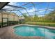 An inviting screened pool is surrounded by a brick deck and green lawn, perfect for relaxation and outdoor enjoyment at 5825 Terncrest Dr, Lithia, FL 33547