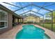 A screened in pool with brick deck and outdoor seating area offers a refreshing escape in this backyard oasis at 5825 Terncrest Dr, Lithia, FL 33547
