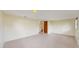 Open basement space featuring tile flooring and a partially carpeted stairwell at 6009 Wilshire Dr, Tampa, FL 33615