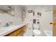 Bathroom featuring a vanity, sink, toilet, and a tub with decorative features at 6009 Wilshire Dr, Tampa, FL 33615