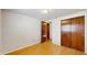 Neutral colored bedroom featuring light hardwood floors and closet with dark wood doors at 6009 Wilshire Dr, Tampa, FL 33615