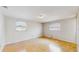 Bright bedroom with light hardwood floors, two windows, and neutral colored walls at 6009 Wilshire Dr, Tampa, FL 33615