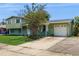 Two-story home with attached garage, brick accents and a mature tree in the front yard at 6009 Wilshire Dr, Tampa, FL 33615