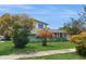 Quaint two-story home with a lush lawn and colorful landscaping at 6009 Wilshire Dr, Tampa, FL 33615