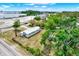 Aerial view of the property with a metal roof, mature trees, and detached shed at 6020 N 50Th St, Tampa, FL 33610