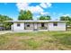 A cozy single-story home with a metal roof, covered porch, and well-maintained landscaping in a residential area at 6020 N 50Th St, Tampa, FL 33610