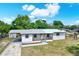 Charming single-story home featuring a metal roof, covered porch, and a carport with well-maintained landscaping at 6020 N 50Th St, Tampa, FL 33610
