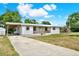 Side view of a charming one-story home with a covered carport, porch, and a well-maintained lawn at 6020 N 50Th St, Tampa, FL 33610