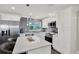 Contemporary kitchen boasts white cabinetry, stainless steel appliances, and a stylish gray backsplash at 6020 N 50Th St, Tampa, FL 33610