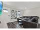 Bright living room features wood flooring, a large gray sectional sofa, and a picture window at 6020 N 50Th St, Tampa, FL 33610