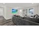 Inviting living room with gray sectional, TV, wood floors, and decor that creates a cozy atmosphere at 6020 N 50Th St, Tampa, FL 33610