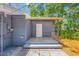Exterior backyard featuring a small patio, door entrance and gray paint at 612 Sw Beverly Ave, Largo, FL 33770