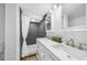 Modern bathroom featuring a dual sink vanity and tiled walk-in shower with decorative pebble floor at 612 Sw Beverly Ave, Largo, FL 33770