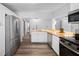 Open-concept kitchen featuring butcher block countertops, stainless appliances, and white cabinets at 612 Sw Beverly Ave, Largo, FL 33770