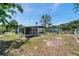 A serene backyard with lush greenery, a screened-in patio, and a view of neighboring properties at 6507 La Mesa Cir, Tampa, FL 33634