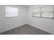 Small bedroom featuring two bright windows and light wood-look tile flooring at 6507 La Mesa Cir, Tampa, FL 33634
