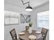 Bright dining area with modern light fixture, contemporary art, and window views at 6507 La Mesa Cir, Tampa, FL 33634